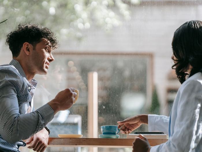 Dos personas conversando con calma frente a un café