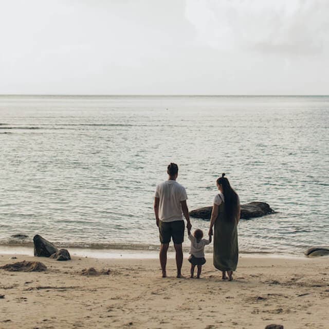 una familia pase en la playa unida, charlando una tarde de verano