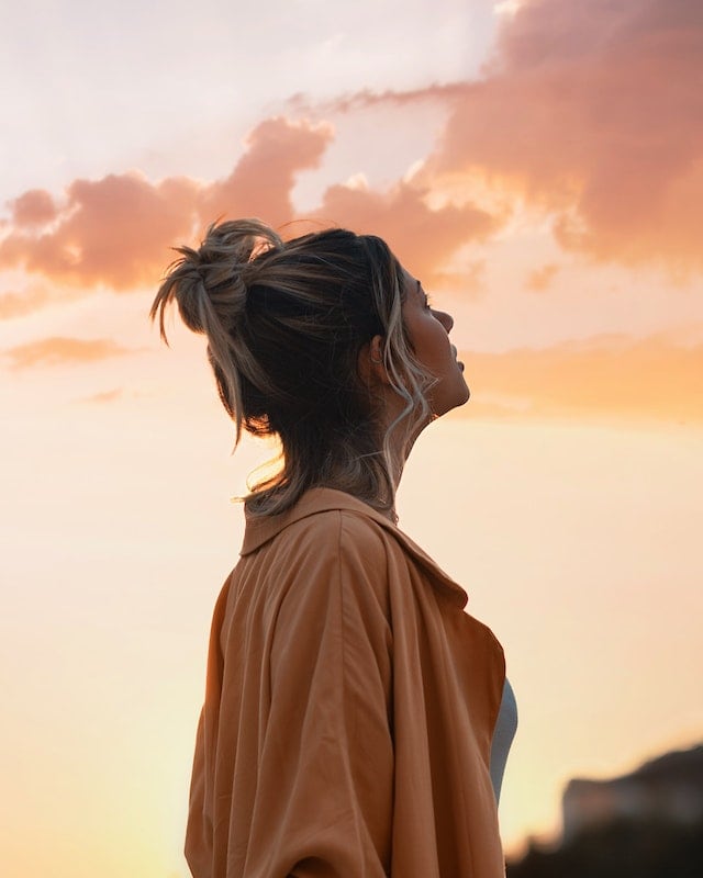 Mujer en la naturaleza observando un atardecer — reflexión y autoconocimiento filosófico